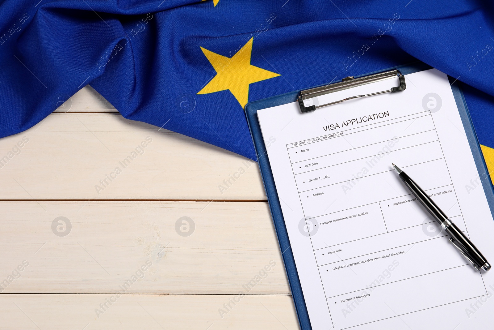 Photo of Visa application form, pen and flag of European Union on white wooden table, flat lay. Space for text