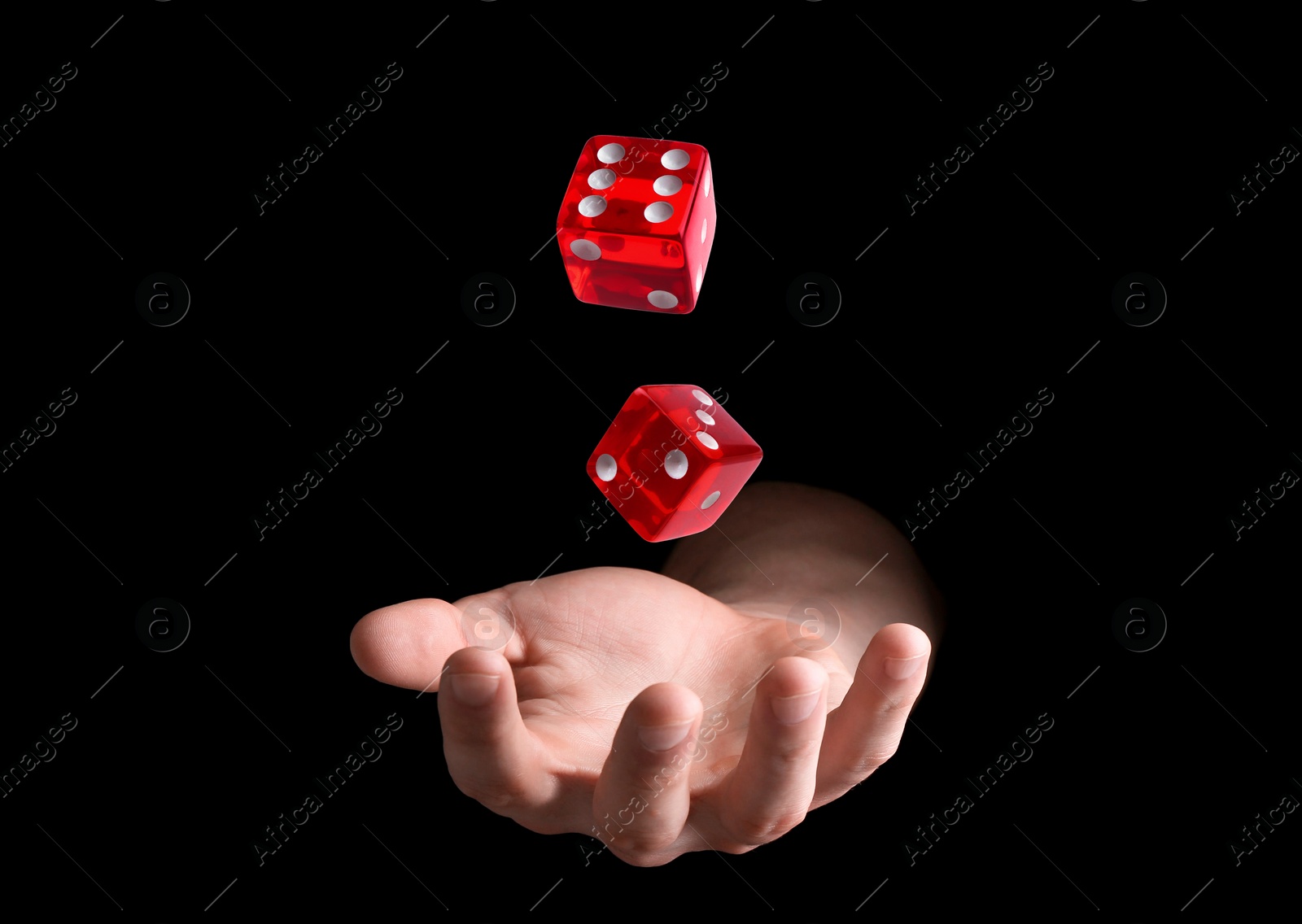 Image of Man throwing red dice on black background, closeup