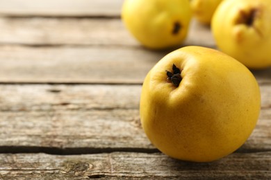 Tasty ripe quinces on wooden table, closeup. Space for text