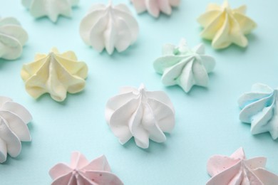 Photo of Delicious meringue cookies on light blue background, closeup