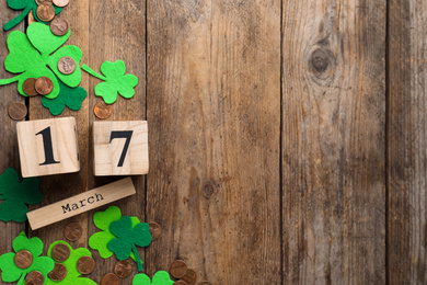 Flat lay composition with block calendar on wooden background, space for text. St. Patrick's Day celebration