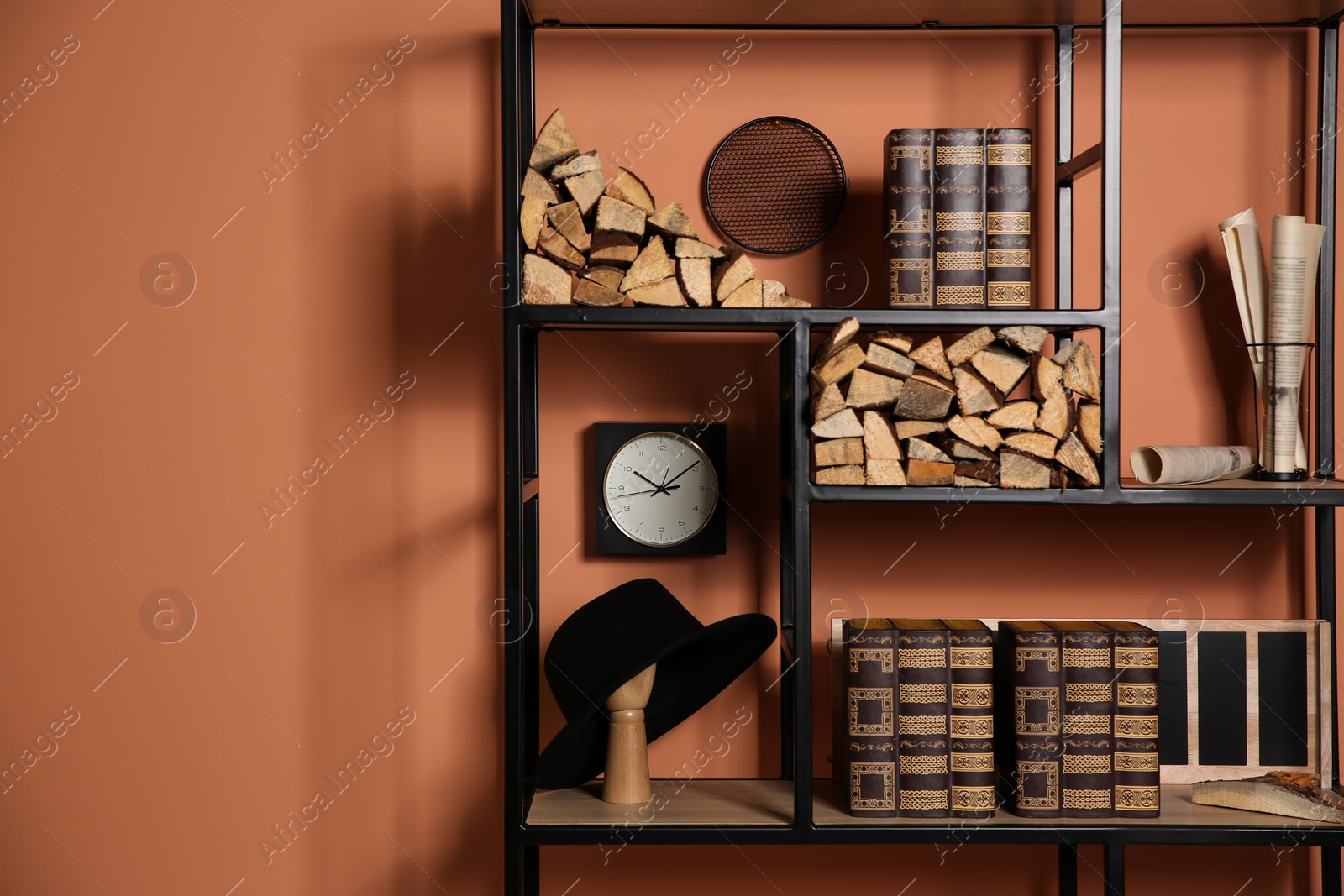 Photo of Stylish shelving unit with decorative elements near color wall. Space for text