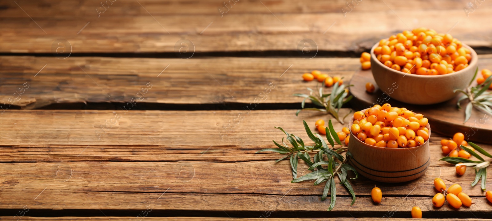 Image of Fresh ripe sea buckthorn on wooden table, space for text. Banner design