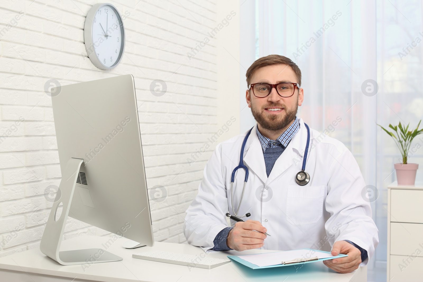 Photo of Portrait of pediatrician at table in clinic