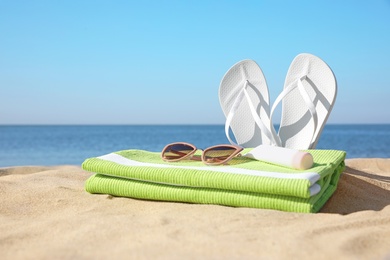 Photo of Set with stylish beach accessories on sand near sea