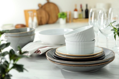 Set of beautiful tableware on white table in kitchen. Space for text