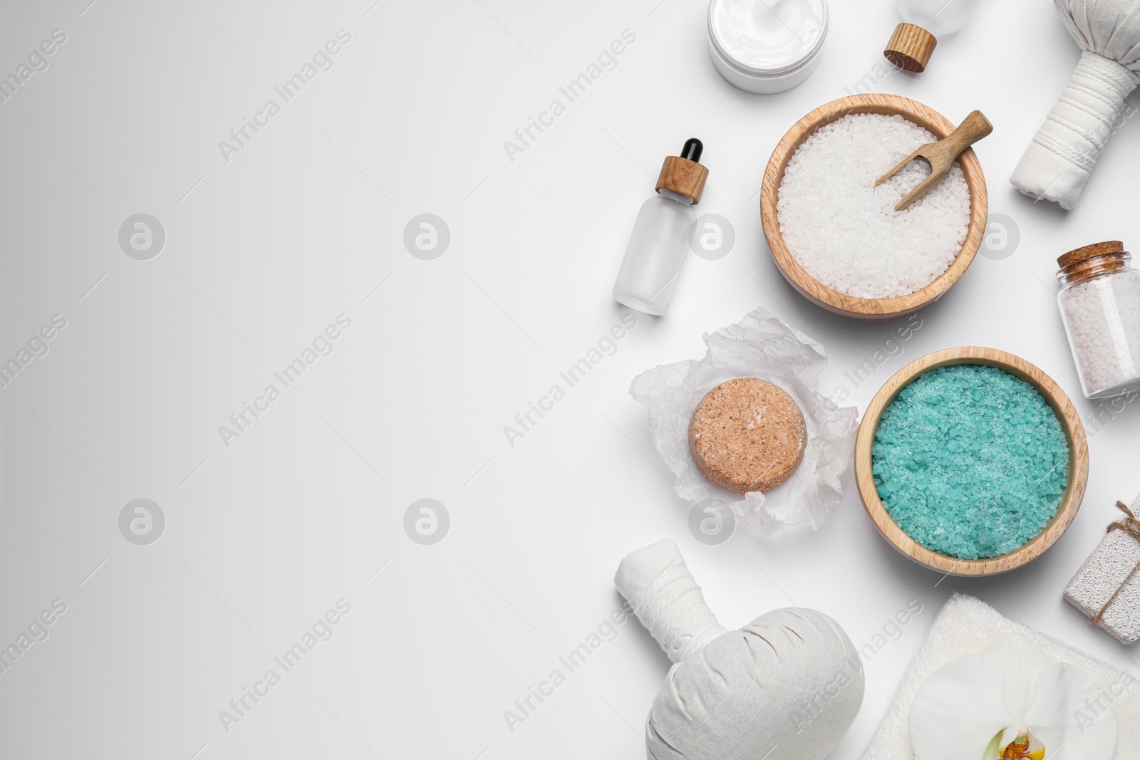 Photo of Beautiful spa composition with herbal massage bags and different care products on white background, flat lay. Space for text