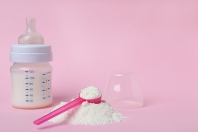 Photo of Powdered infant formula with scoop and feeding bottle on pink background, space for text. Baby milk