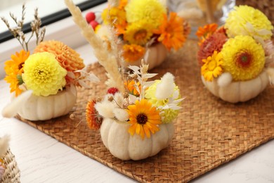 Photo of Composition with small pumpkins, beautiful flowers and spikelets on white window sill indoors, closeup