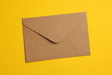 Photo of Envelope made of parchment paper on yellow background, top view