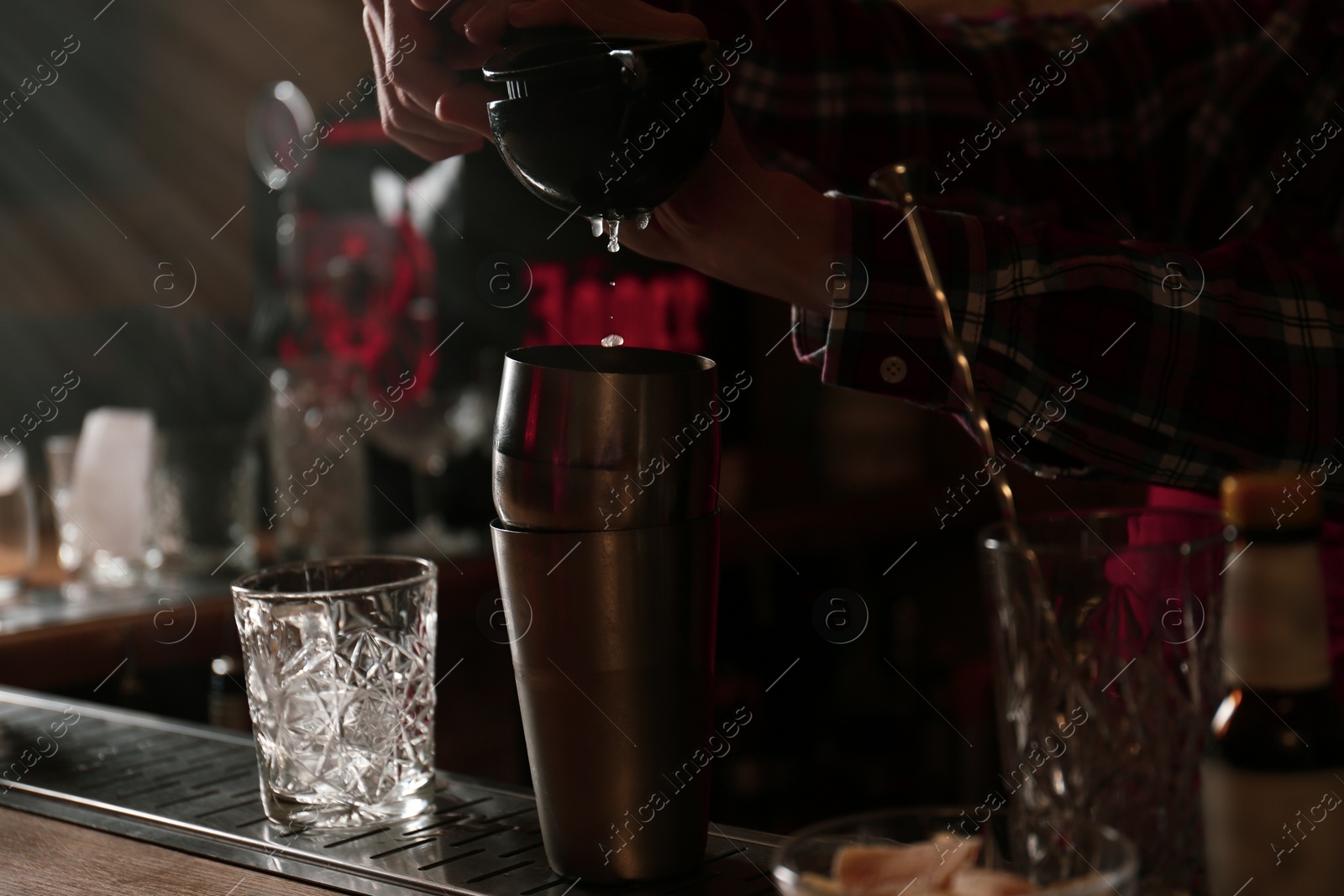 Photo of Bartender preparing fresh alcoholic cocktail at bar counter, closeup