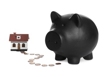 Piggy bank, house model and coins on white background. Saving money concept