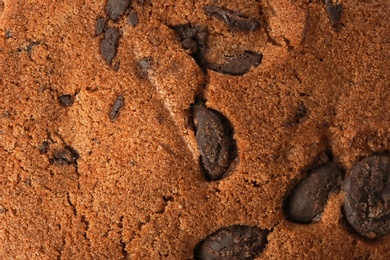 Photo of Tasty cookie with chocolate chips as background, top view