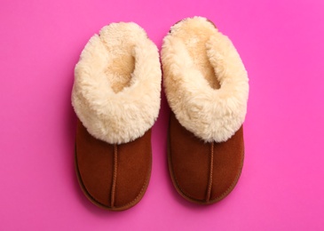 Photo of Pair of stylish soft slippers on pink background, flat lay