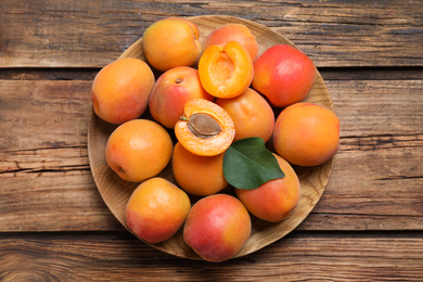 Photo of Delicious fresh ripe apricots on wooden table, top view