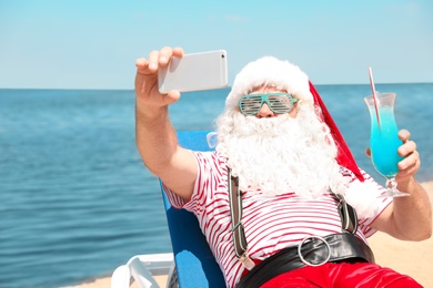 Photo of Authentic Santa Claus taking selfie at resort