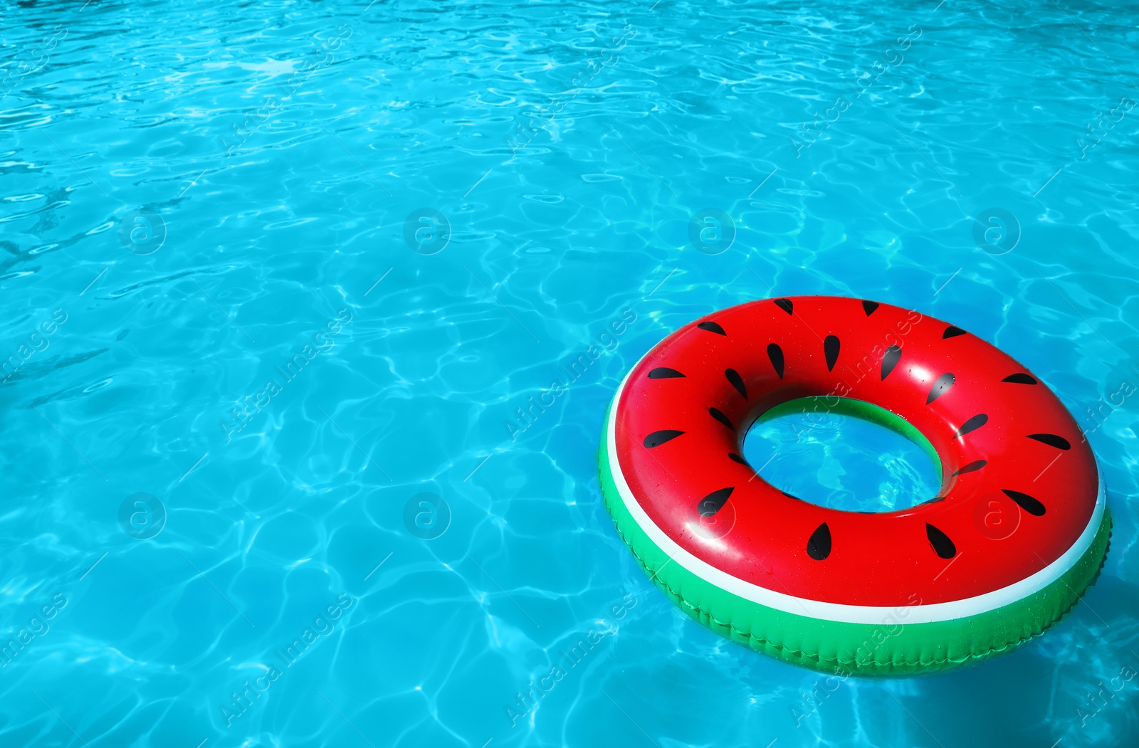 Photo of Inflatable ring floating in swimming pool on sunny day. Space for text