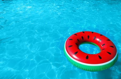 Photo of Inflatable ring floating in swimming pool on sunny day. Space for text