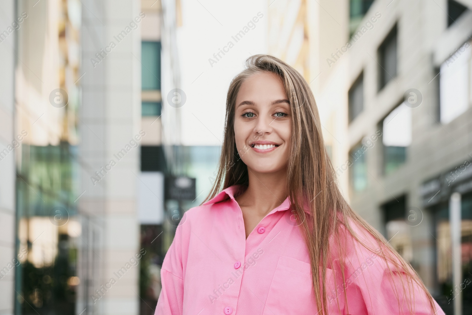 Photo of Beautiful young woman in stylish shirt on city street