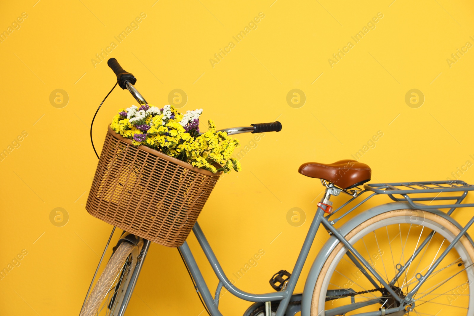 Photo of Retro bicycle with wicker basket on color background