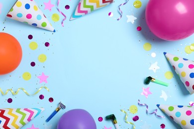 Photo of Frame made of party hats and birthday decor on light blue background, flat lay. Space for text.