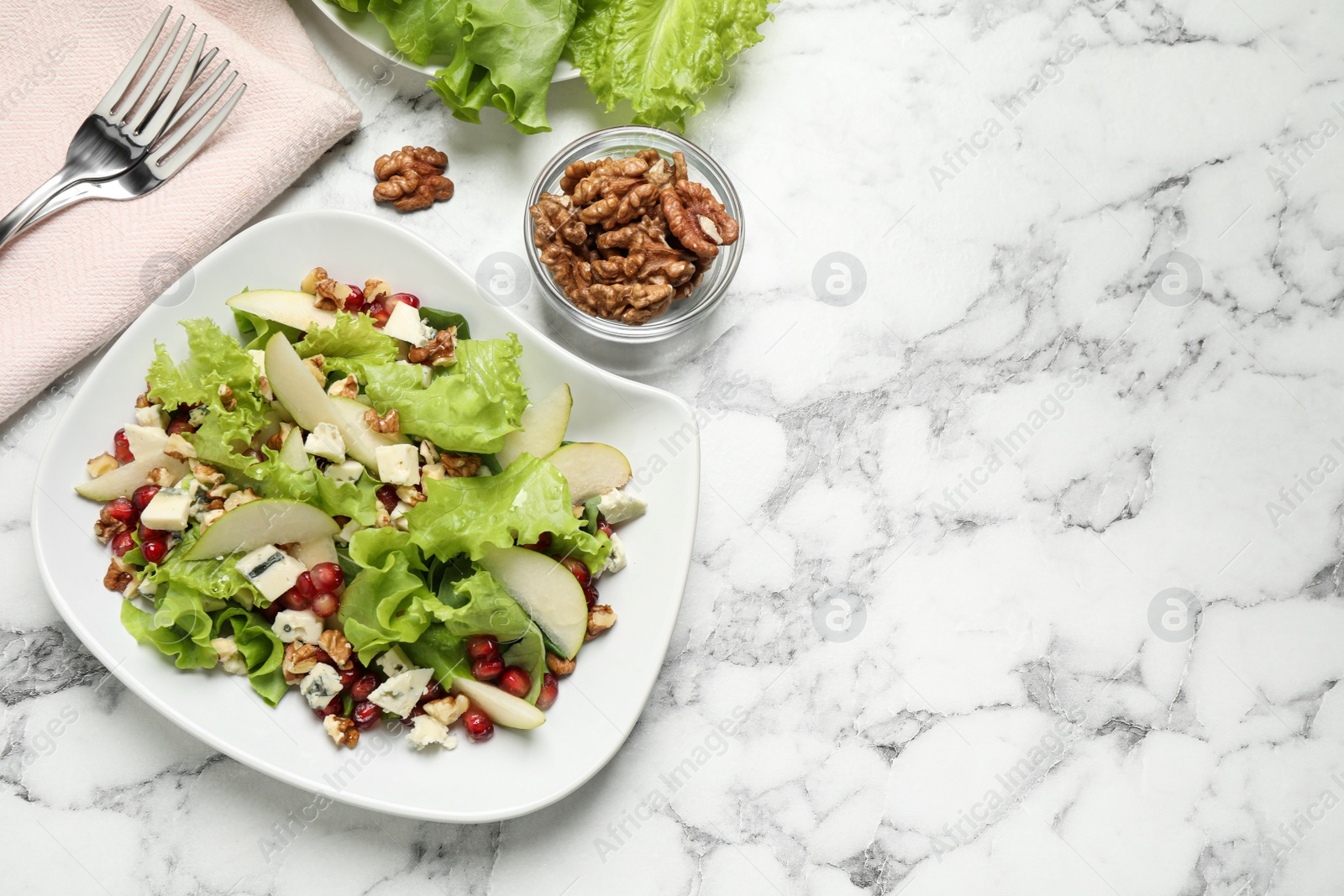 Photo of Tasty salad with pear slices and walnuts on white marble table, flat lay. Space for text