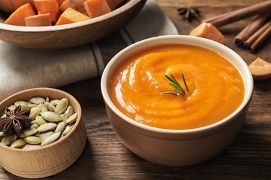 Photo of Bowl of tasty sweet potato soup served on table