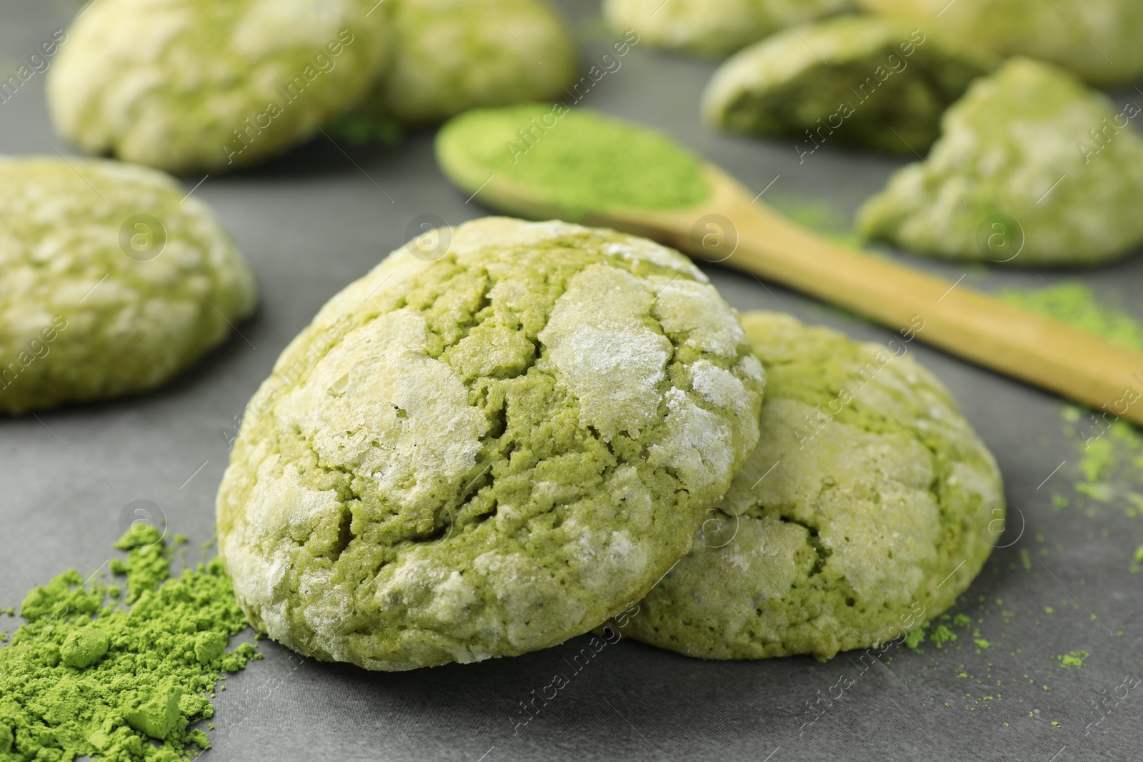 Photo of Tasty matcha cookies and powder on grey table, closeup