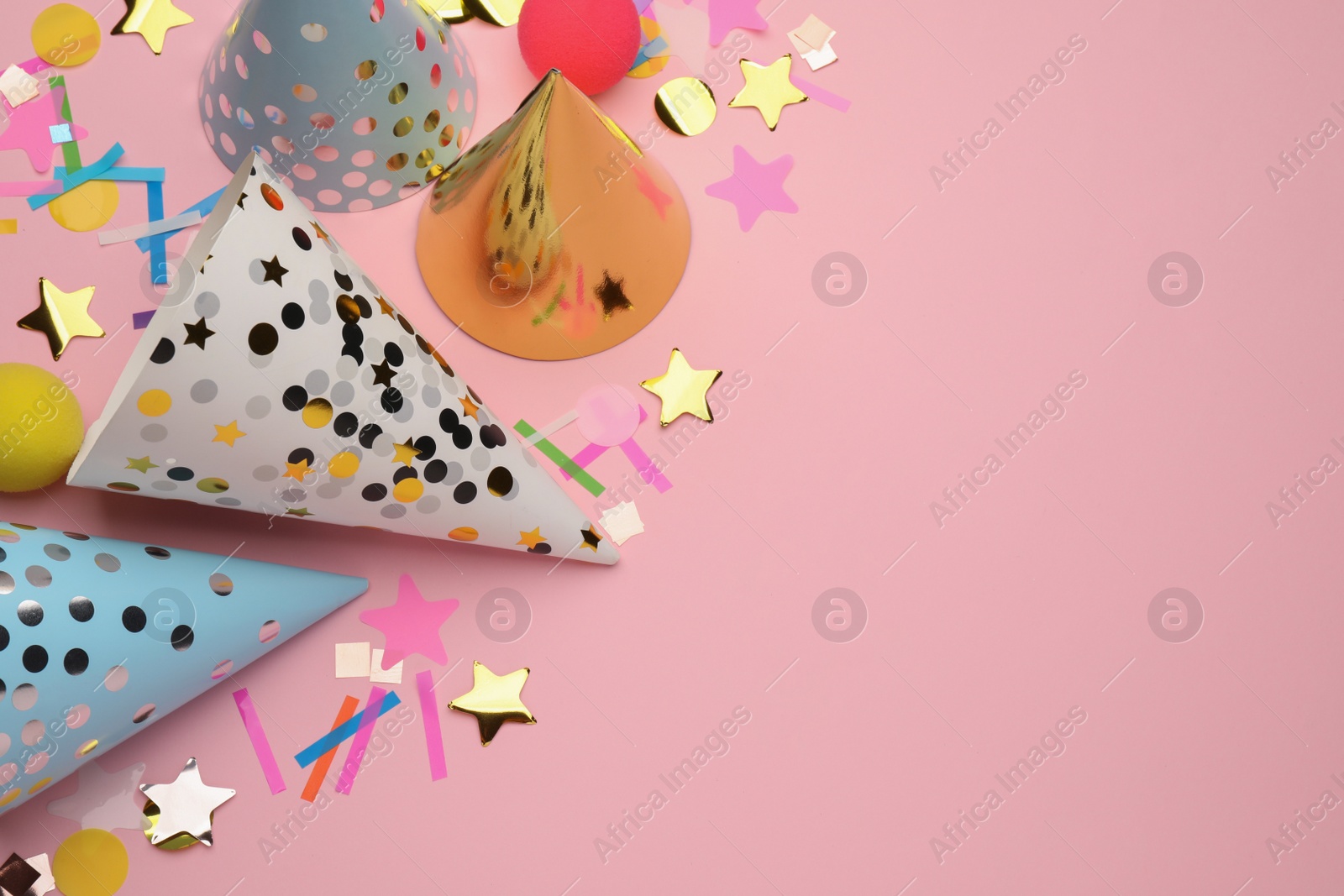 Photo of Flat lay composition with party hats and other festive items on pink background. Space for text