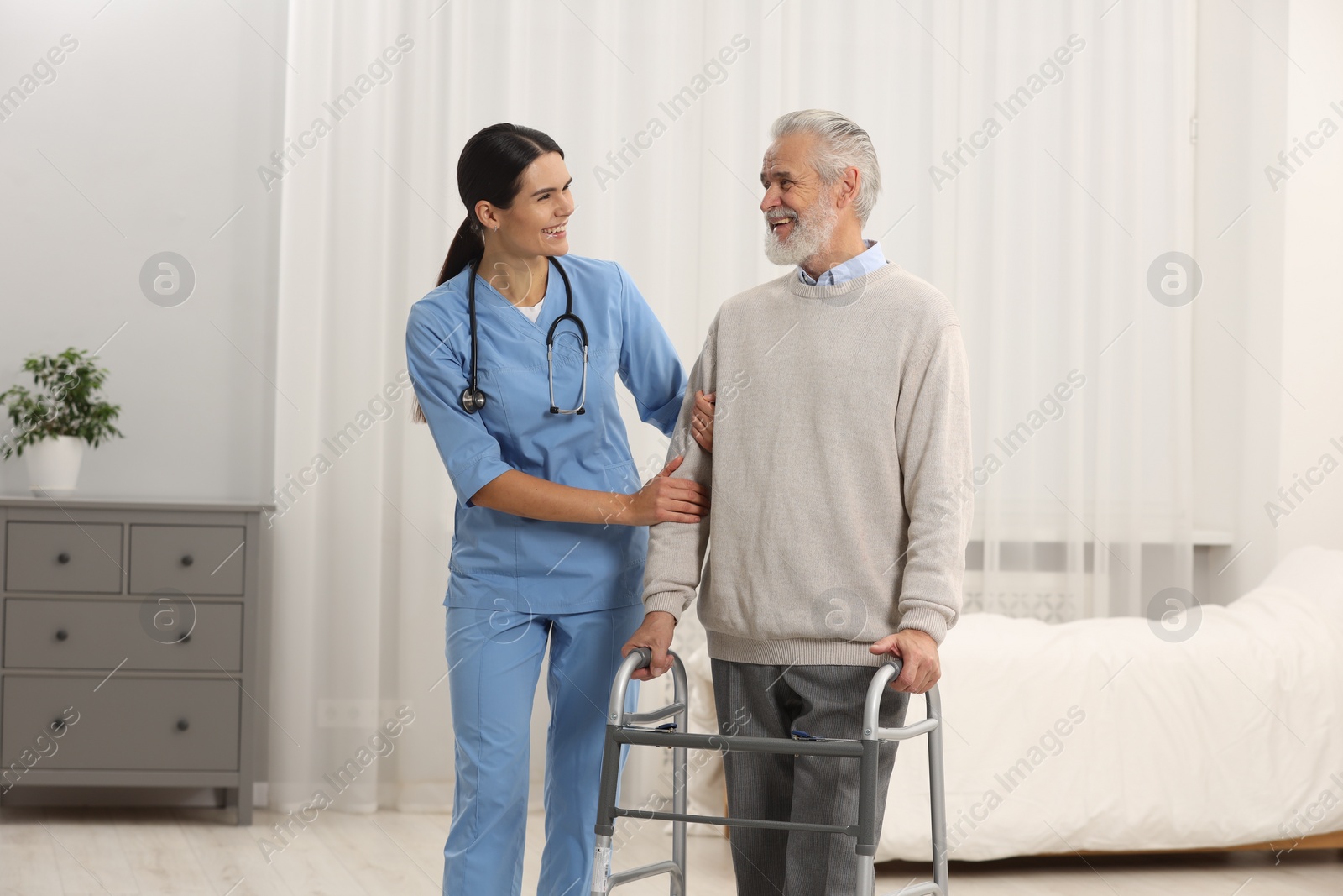 Photo of Health care and support. Nurse laughing with elderly patient in hospital