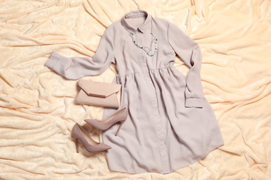 Photo of Flat lay composition with stylish grey dress on beige blanket