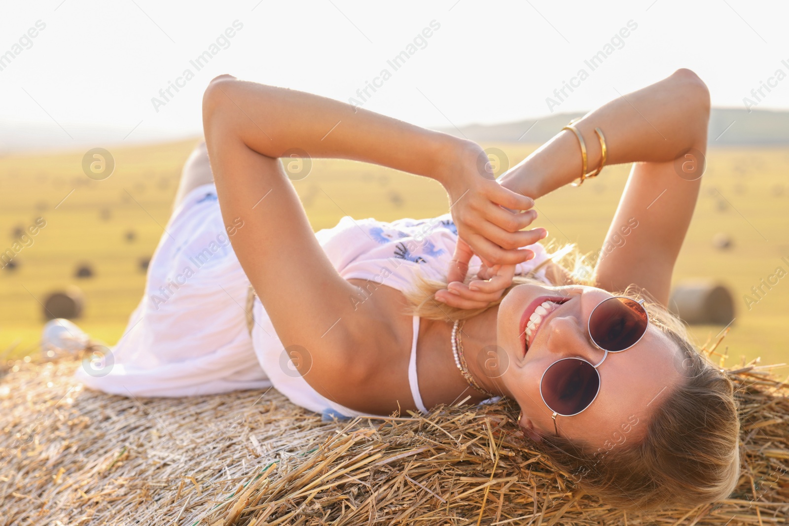 Photo of Beautiful hippie woman on hay bale in field