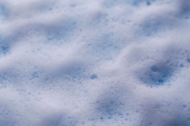 Photo of White foam on light blue background, closeup