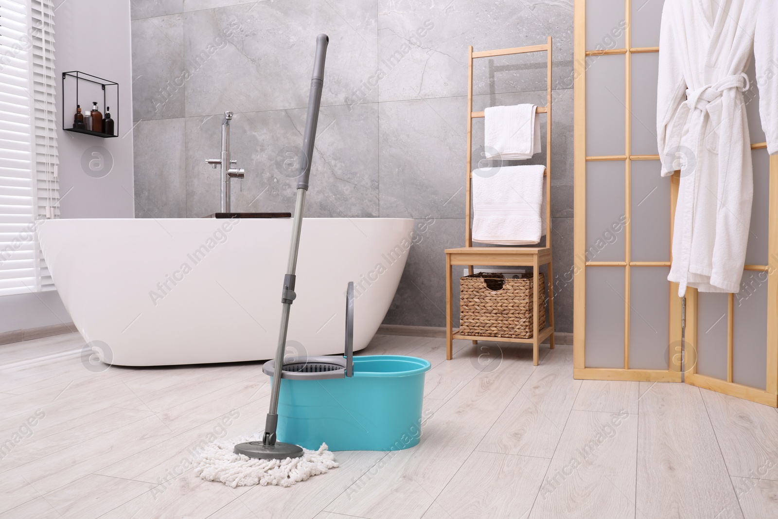 Photo of Mop and plastic bucket in bathroom. Cleaning floor