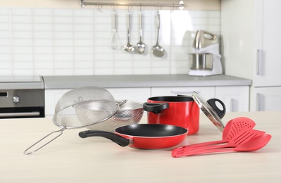 Set of clean cookware and utensils on table in kitchen