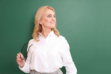 Happy professor with glasses near green board, space for text