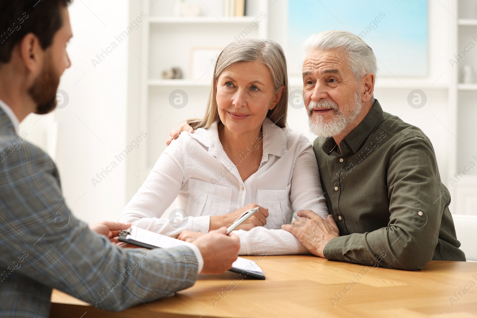 Photo of Notary consulting senior couple about Last Will and Testament in office