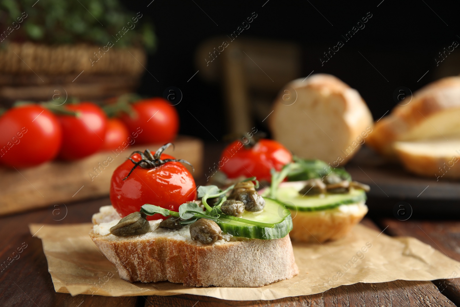 Photo of Tasty bruschettas with vegetables and capers served on wooden table, closeup