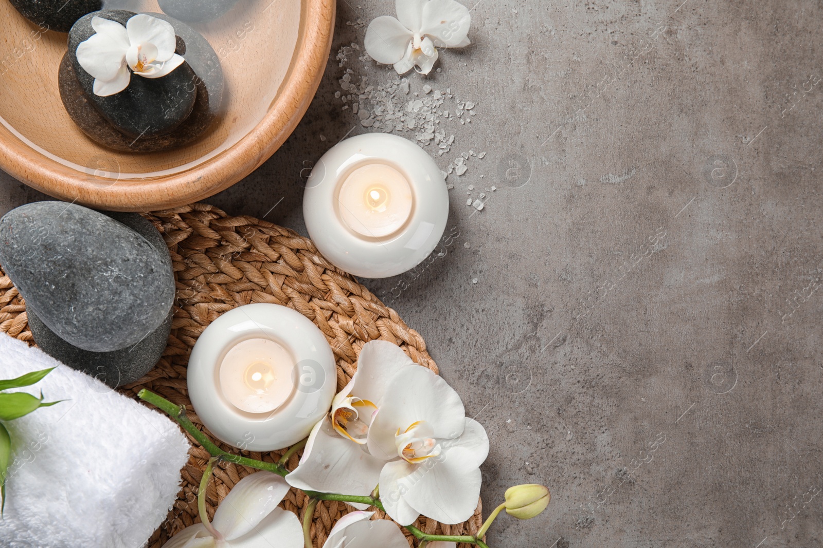 Photo of Flat lay composition with spa stones and candles on gray background. Space for text