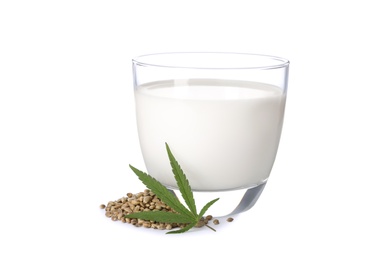 Photo of Glass of hemp milk, seeds and leaf on white background