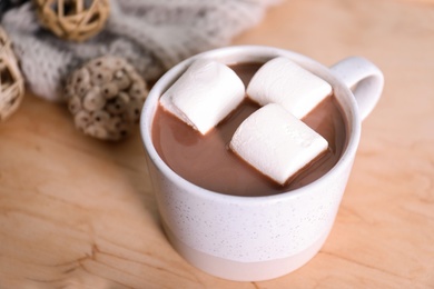 Photo of Cup of aromatic cacao with marshmallows on wooden table, closeup