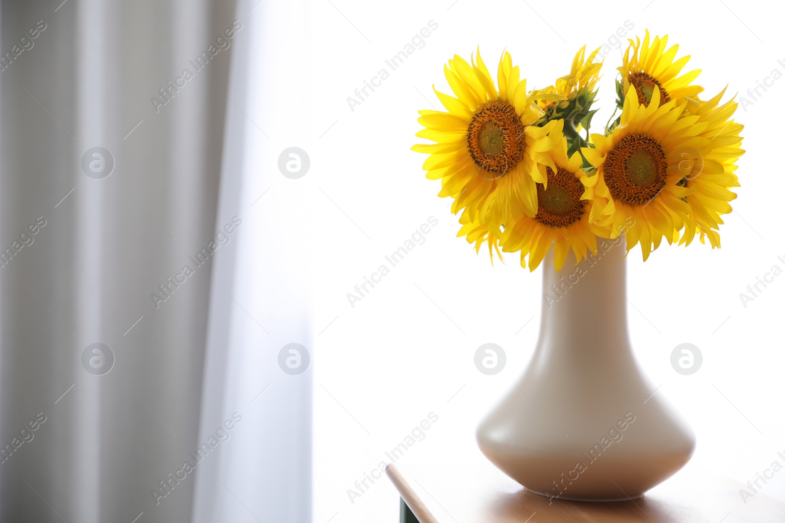 Photo of Bouquet of beautiful sunflowers on table indoors. Space for text