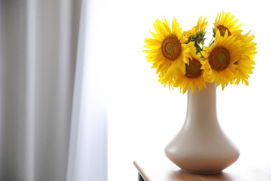 Photo of Bouquet of beautiful sunflowers on table indoors. Space for text