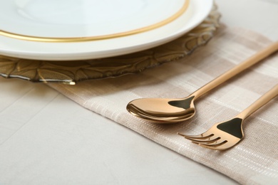 Beautiful table setting with gold cutlery on grey background