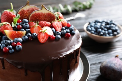 Photo of Fresh delicious homemade chocolate cake with berries on dark table