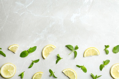 Fresh mint with sliced lemon on grey marble background, flat lay. Space for text