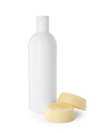 Photo of Solid shampoo bars and bottle of cosmetic product on white background