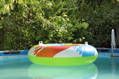 Photo of Inflatable ring floating on water in above ground swimming pool outdoors