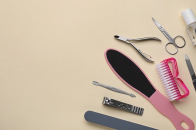 Photo of Set of pedicure tools on beige background, flat lay. Space for text