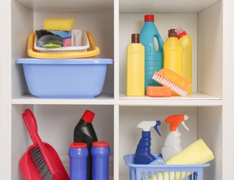 Photo of Shelving unit with different cleaning supplies and tools on shelves